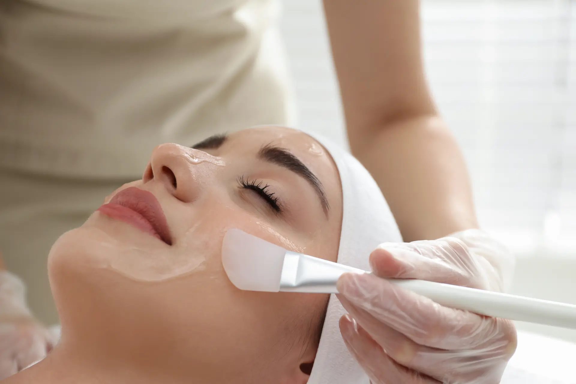 Woman receiving a professional chemical peel treatment for smoother, radiant skin at Dr. Sanaz Harirchian’s Houston facial plastic surgery clinic.